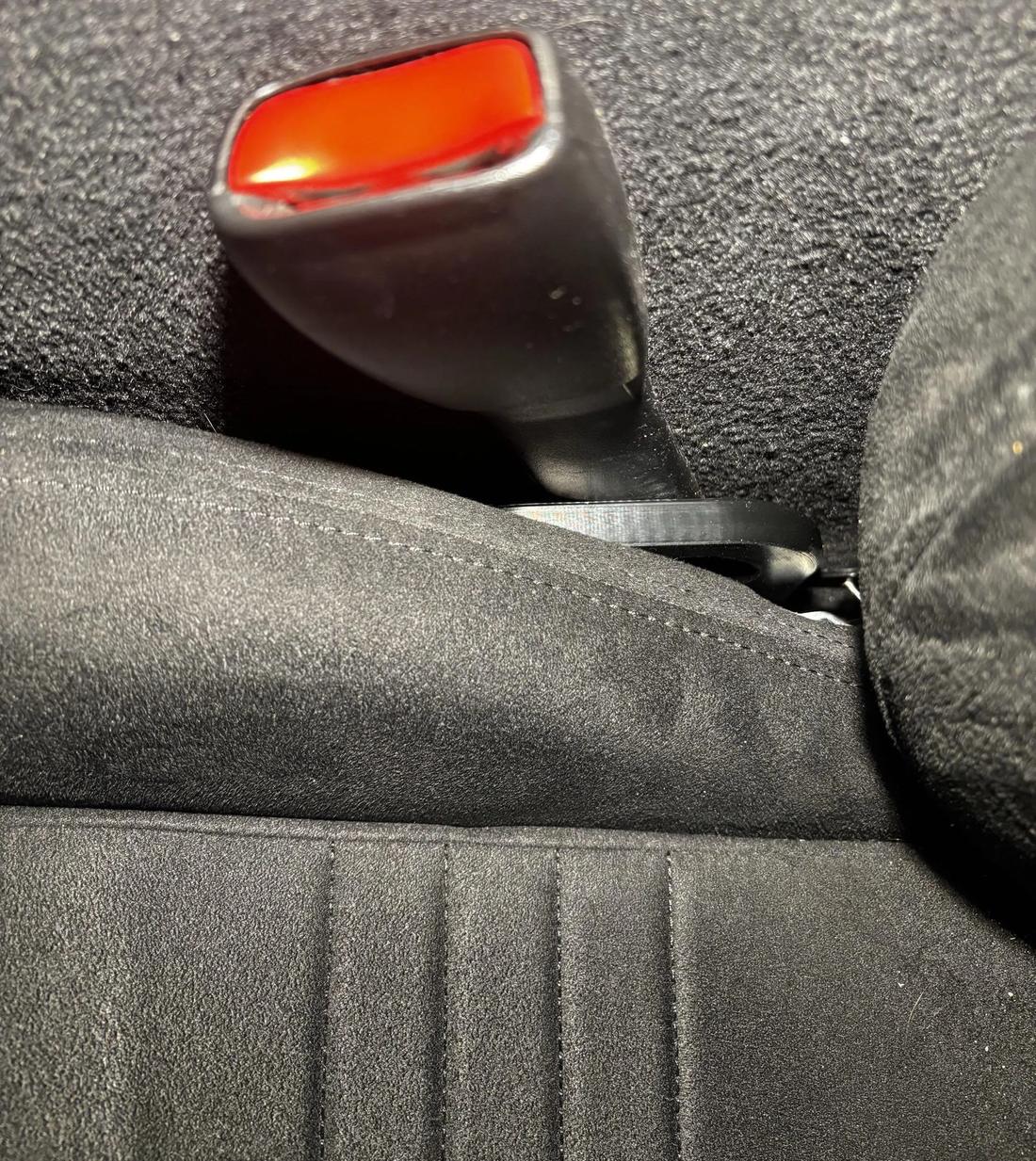Lever extension next to the seat belt buckle